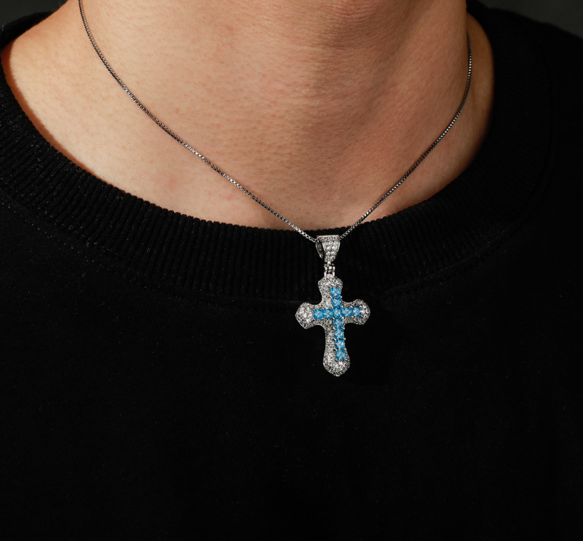 Necklace with a cross pendant featuring blue stones on a black background